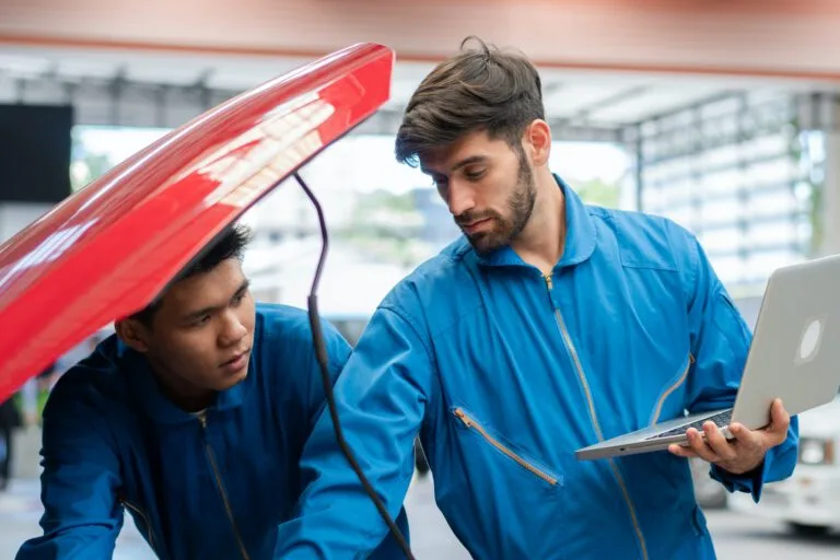 Dudley Auto Service technicians running diagnostics on a car engine